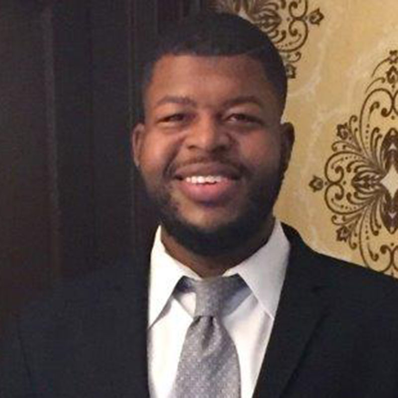 Demetrius Terrell of Philadelphia smiling in a black suit and tie