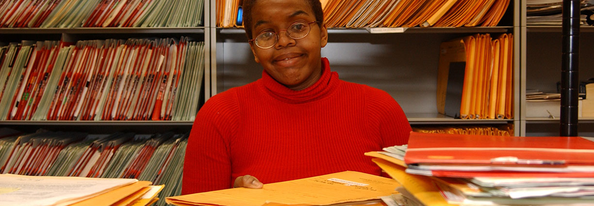 student holding folder in library